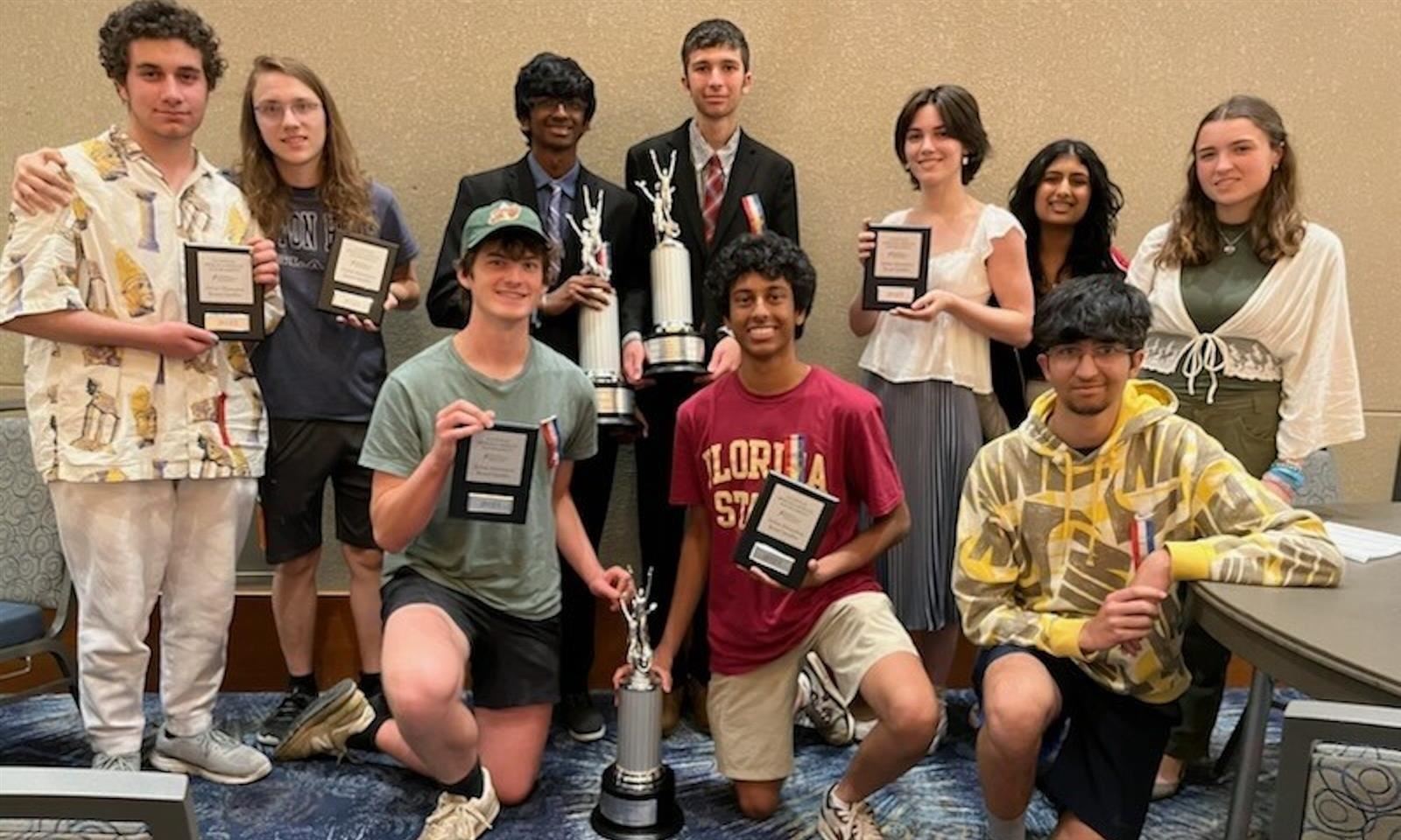 Students hold trophies